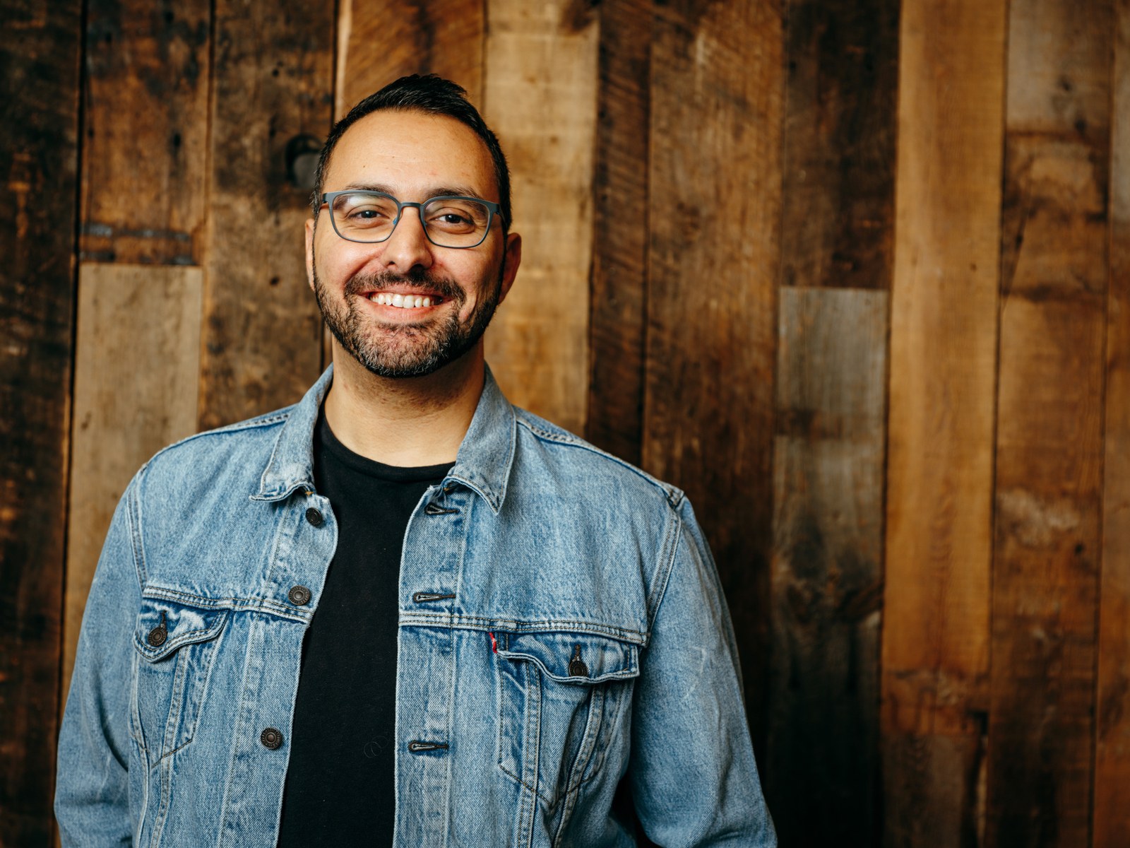 Michael Venia in a denim jacket, smiling