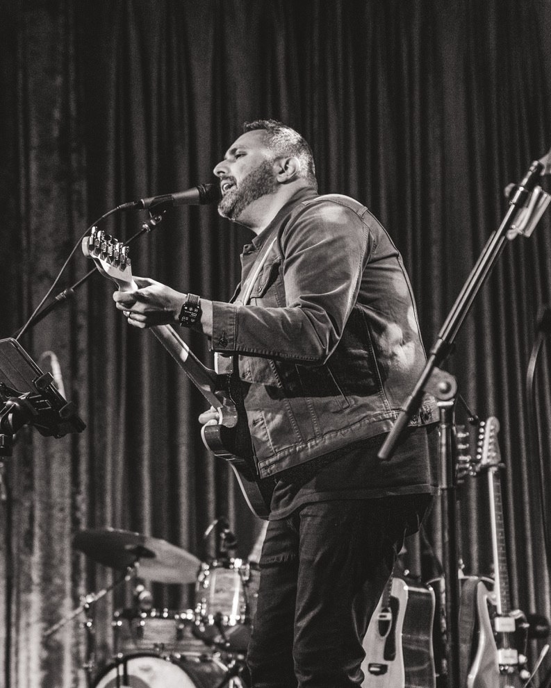Michael Venia on stage with a guitar